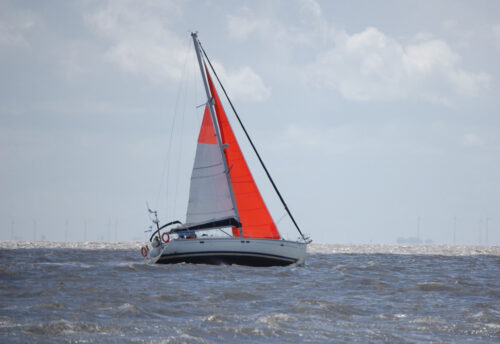 sailing with bright orange storm jib and reefed mainsail